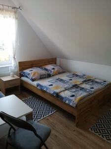 ein Schlafzimmer mit einem Bett, einem Stuhl und einem Fenster in der Unterkunft Pokoje u Izy Stare Kiejkuty in Szczytno