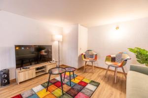 - un salon avec deux chaises et une télévision dans l'établissement Appartement spacieux Luna Park centre, à Clermont-Ferrand