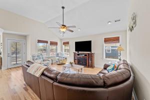a living room with a brown leather couch at Killin' Time in Kill Devil Hills
