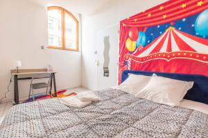 um quarto com uma cama com uma tenda de circo como pano de fundo em Appartement spacieux Luna Park centre em Clermont-Ferrand