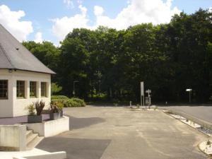 un aparcamiento vacío frente a un edificio en Hotel-Restaurant Du Lac, en Joué-lès-Tours