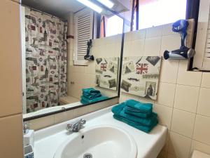 y baño con lavabo y espejo. en La Dehesa House, en Santiago