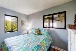 1 dormitorio con cama y espejo en Plantation East #3326, en Gulf Highlands