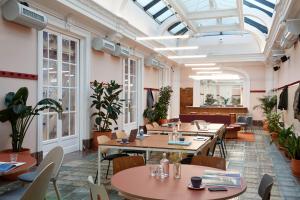 Un restaurante con mesas, sillas y ventanas. en The Social Hub Madrid, en Madrid 37 fotos más