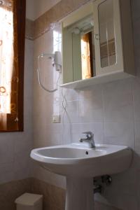 y baño con lavabo blanco y espejo. en Locanda della Pescheria en Comacchio