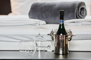 a bottle of champagne and glasses on a table next to a bed at Boutique Hotel am Markt in Melle