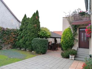 a house with a patio and a porch with bushes at Ubytování Na Špacíru in Mikulov