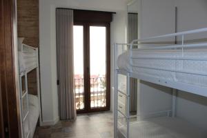 a bedroom with bunk beds and a door with a balcony at SUITE DEL CASTILLO in Andújar