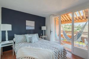 um quarto com uma cama e uma rede de descanso em La Pélagie - Maison climatisée vue mer em Sainte-Maxime