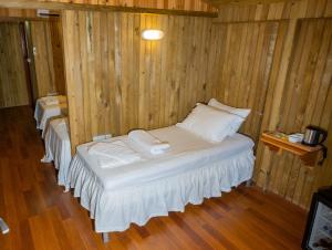 a room with two beds in a wooden wall at Tree Houses Hotel in Fethiye