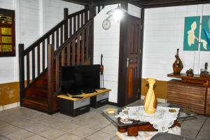 a living room with a tv and a staircase at Chalet WEITHY in Bois dʼInde