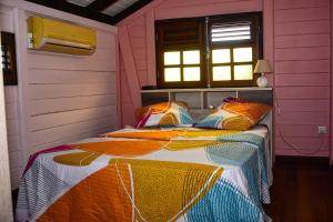 ein Schlafzimmer mit einem Bett in einem rosa Zimmer in der Unterkunft Chalet WEITHY in Bois dʼInde