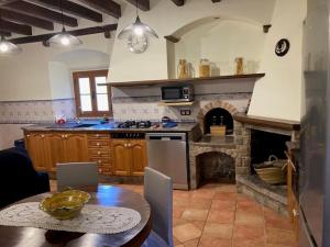a kitchen with a fireplace and a table with a dining room at Can Homs in Beuda