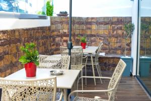 an outdoor patio with tables and chairs and a brick wall at New York Hotel in Rhodes Town