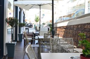 a restaurant with tables and chairs and an umbrella at New York Hotel in Rhodes Town