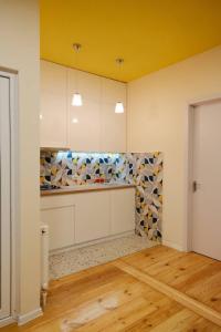 Bolnisi的住宿－Guest House Bolnisi - Duplex apartment，厨房配有白色橱柜和黄色天花板