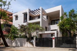 a white house with a black fence in front of it at Villa 9C by Revkeys in Bangalore