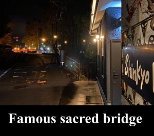 a picture of a street at night with the words famous sacred bridge at Shinkyo Inn in Nikko