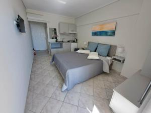 a bedroom with a large bed and a kitchen at Aretousa in Tolo
