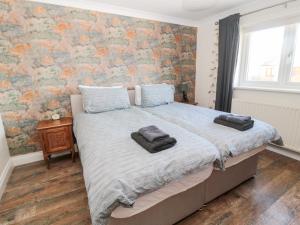 um quarto com uma cama com duas toalhas em The Croft em Alnwick
