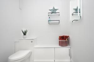 La salle de bains blanche est pourvue de toilettes et d'un lavabo. dans l'établissement Cowdray Avenue, à Colchester