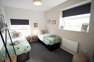 - une chambre avec 2 lits et une fenêtre dans l'établissement Ideal Lodgings in Walkden, 