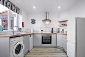 eine weiße Küche mit Waschmaschine und Trockner in der Unterkunft Cowdray Avenue in Colchester
