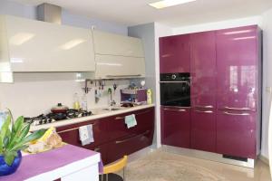 a kitchen with red cabinets and a purple refrigerator at Holiday Home Uma in Visoko