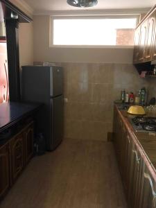 a kitchen with a black refrigerator and a window at Nikea 51 Apartment in Kutaisi