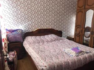 a bedroom with a bed with a pink comforter at Nikea 51 Apartment in Kutaisi