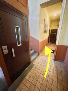 un pasillo con una puerta y una flecha amarilla en el suelo en Domus Vacanza en Milán