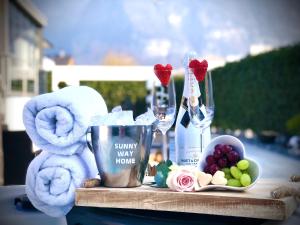 Sunny Way Home Accommodation & Spa في Weite: طاولة مليئة بالمناشف واكواب النبيذ والفواكه