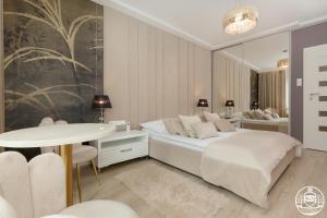 um quarto com uma cama, uma mesa e um espelho em Nadmorskie Tarasy - Apartments M&M em Kolobrzeg