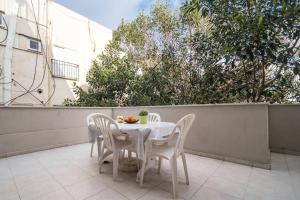 - Balcón con mesa blanca y sillas en Lovely 2 rooms with big terrace en Tel Aviv