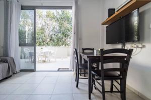 comedor con mesa, sillas y TV en Lovely 2 rooms with big terrace en Tel Aviv
