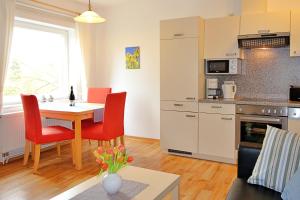 a kitchen and living room with a table and chairs at Meeresblick Fehmarn in Fehmarn