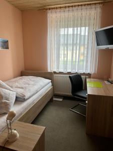 - une chambre avec un lit, un bureau et une télévision dans l'établissement Gasthof „Zum Schwan“, à Langenbach