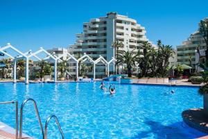 a large swimming pool with people in the water at benalbeach 51 in Benalmádena