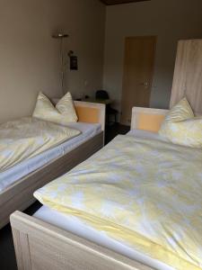 - deux lits assis l'un à côté de l'autre dans une pièce dans l'établissement Gasthof „Zum Schwan“, à Langenbach