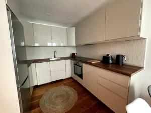 a kitchen with white cabinets and a wooden floor at Stylish 2BR contemporary design perfect vacation in Gibraltar