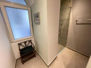 a bathroom with a shower and a window and a chair at Stylish 2BR contemporary design perfect vacation in Gibraltar