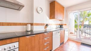 a kitchen with wooden cabinets and a large window at Casa Mariposa in Alhaurín el Grande