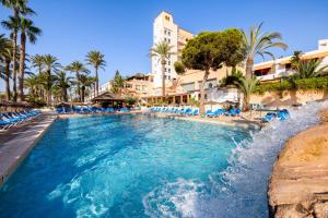 una piscina en un complejo con sillas azules y palmeras en Playadulce, en Aguadulce