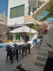 a dog laying next to a table with an umbrella at Casa Sol Naciente in Cartagena de Indias