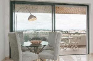 una sala da pranzo con tavolo, sedie e finestra di Marina Vilamoura Aquamar 504 by VilamouraSun a Vilamoura