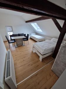 a attic room with a bed and a table and chairs at Das Haus im Biosphärengebiet Schwäbische Alb in Dornstadt