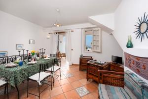 ein Wohnzimmer mit Tisch und Stühlen und einer Couch in der Unterkunft Villa Al Faro San Vito in San Vito lo Capo