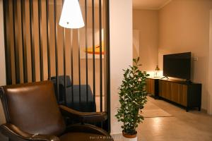 a living room with a chair and a television at Casa Ferretti apartment in Brindisi