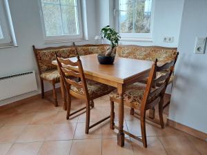 una mesa de comedor y sillas con una maceta. en Casa Sandra en Villach