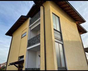 żółty budynek z balkonami na boku w obiekcie La Corte di Silvia Malpensa w mieście Cardano al Campo